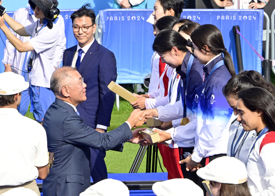 Hyundai Motor Group Executive Chair Euisun Chung delivers gold medals to Korean archers Jeon Hun-young, Lim Si-hyeon and Nam Su-hyeon as they beat China in the women's team archery gold medal match to win Korea’s 10th straight Olympic gold in the event at the Invalides in Paris on Sunday. [KOREA ARCHERY ASSOCIATION] 