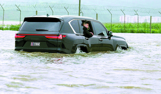 North Korea’s leader Kim Jong-un is spotted in a vehicle as he visits flooded areas in Sinuiju and Uiju County in North Pyongan Province Sunday to guide an operation to rescue thousands of residents isolated in the areas in a photo carried by its official Rodong Sinmun on Monday. [YONHAP]