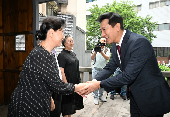 Seoul Mayor Oh Se-hoon, right, shakes hands with a descendant of an independence activist at the provisional government of Korea in Chongqing, Sichuan Province, China, on Sunday. [SEOUL METROPOLITAN GOVERNMENT]