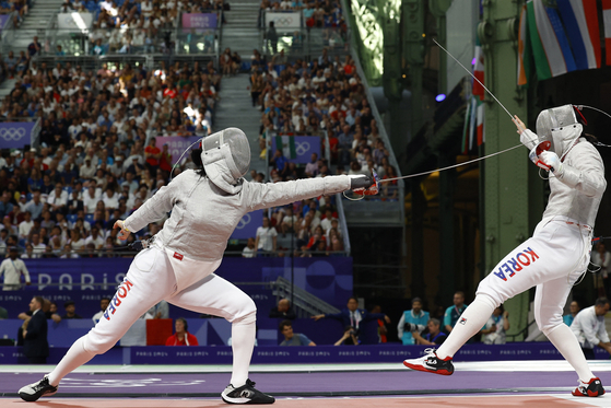 Choi Se-bin, left, in action against Jeon Ha-young in the round of eight of the women's individual sabre contest at the 2024 Paris Olympics at Grand Palais in Paris on Monday.  [REUTERS/YONHAP]