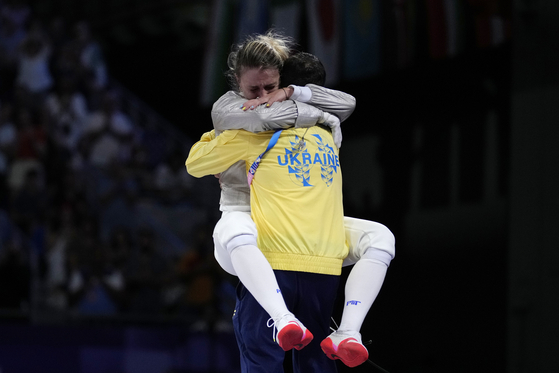 Ukraine's Olga Kharlan celebrates with her coach after winning the women's individual sabre bronze medal match against Korea's Choi Se-bin at the Grand Palais in Paris on Monday.  [AP/YONHAP]