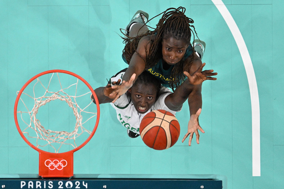 Australia's Ezi Magbegor fighting for the ball with Nigeria's Murjanatu Musa in a women's preliminary round Group B basketball match during the Paris Olympics at the Pierre-Mauroy stadium in Villeneuve-d'Ascq, France on Monday. [AFP/YONHAP]
