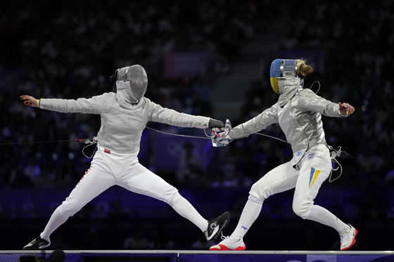 Korea's Choi Se-bin, left, competes with Ukraine's Olga Kharlan in the women's individual sabre bronze medal match during the Paris Olympics at the Grand Palais in Paris on Monday.  [AP/YONHAP]