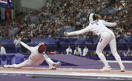 Korean fencer Song Se-ra, left, attacks during the women’s epee team table of eight against France at the Paris Olympics at Grand Palais in Paris on Tuesday. [YONHAP]