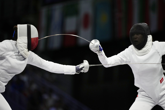 Poland's Aleksandra Jarecka, left, competes with China's Xu Nuo in the women's team epee bronze final match at the Grand Palais in Paris on Tuesday.  [AP/YONHAP]