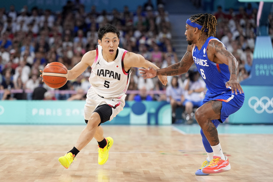 Japan's Yuki Kawamura, left, drives past France's Andrew Albicy in a men's basketball game at the Paris Olympics in Villeneuve-d'Ascq, France on Tuesday. [AP/YONHAP]