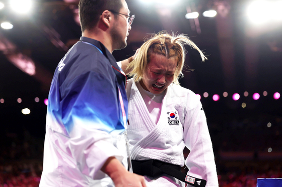 Korean judoka Kim Ji-su, right, reacts after losing to Lubjana Piovesana of Austria in the women’s -63 kilogram repechage contest at the Paris Olympics on Tuesday at the Champ-de-Mars Arena in Paris. [JOINT PRESS CORPS]