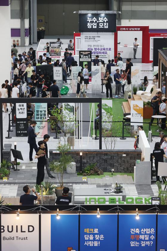  Visitors look around exhibition booths at the 2024 Korea Build Week, a construction trade show, held at Coex in Gangnam District, southern Seoul, on Wednesday. [YONHAP]
