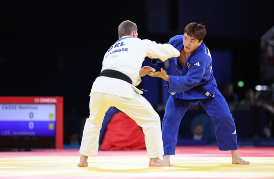 Korean judoka Lee Joon-hwan, right, competes in the men’s -81 kilogram bronze medal match at the Paris Olympics against Matthias Casse of Belgium at the Champ-de-Mars Arena in Paris on Tuesday. [JOINT PRESS CORPS]
