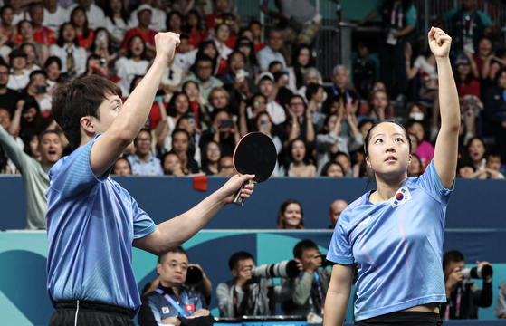 Korean table tennis players Shin Yu-bin, right, and Lim Jong-hoon celebrate after a victory over Wong Chun Ting and Doo Hoi Kem of Hong Kong in the mixed doubles bronze medal match at the Paris Olympics on Tuesday at South Paris Arena 4 in Paris. [NEWS1]