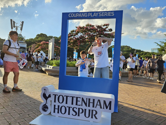 A father and a son wearing Tottenham Hotspur jerseys pose at a photo zone at Seoul World Cup Stadium in western Seoul on Wednesday ahead of a Coupang Play Series match between Spurs and Team K League. [PAIK JI-HWAN]