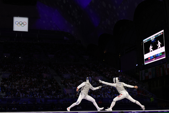 Italy's Filippo Macchi, left, and Hong Kong's Cheung Ka Long compete in the men's foil individual gold medal bout during the Paris Olympics at the Grand Palais in Paris on Monday. [AFP/YONHAP]