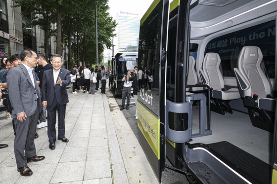 Science Minister Lee Jong-ho, right, and Chairman of the Personal Information Protection Commission Ko Hak-soo,left, test ride an autonomous bus departing from Cheonggye Plaza in Jung District, central Seoul, on Wednesday. [YONHAP]