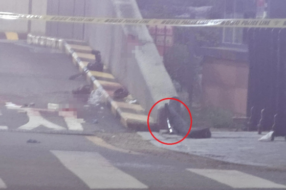 An object circled in red, assumed to be a long sword used to attack a 43-year-old victim, lies on the road where the offense took place in Eunpyeong District, northern Seoul. [SCREEN CAPTURE]