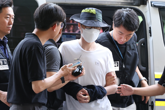 Officers escort Baek, a 37-year-old murder suspect, to the Seoul Western District Court for a questioning session before the court ruling on his arrest warrant on Thursday in western Seoul. [NEWS1] 