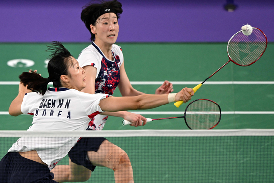 Korea's Baek Ha-na, front, plays a shot in the women's doubles badminton quarterfinal match against China during the Paris Olympics at Porte de la Chapelle Arena in Paris on Thursday. [AFP/YONHAP]