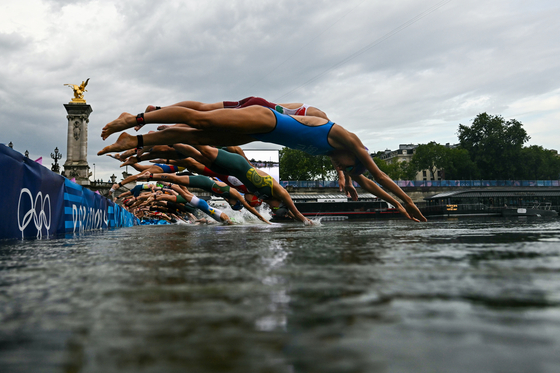 Athletes compete in the swimming segment of the women's individual triathlon at the Paris Olympics in Paris on Wednesday. [XINHUA/YONHAP]