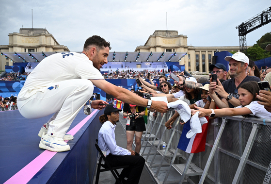 Mountain bike men's cross-country silver medallist Victor Koretzky of France interacts with fans during the Champions Park medalists celebrations at Trocadero in Paris on Wednesday. [REUTERS/YONHAP]