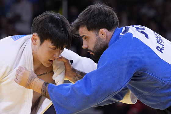 Korea's Han Ju-yeop and Brazil's Rafael Macedo compete in a men's -90-kilogram repechage round match at the Champ-de-Mars Arena in Paris on Wednesday.  [AP/YONHAP]