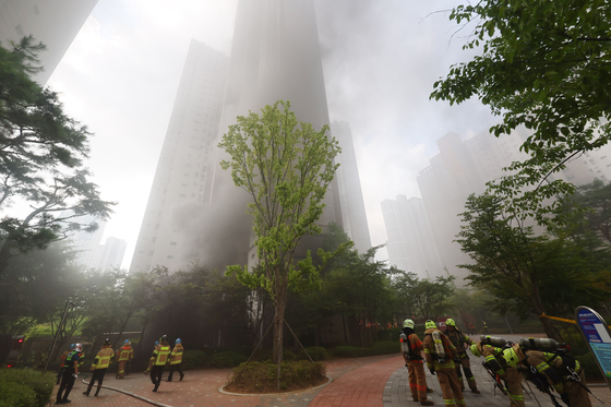 An apartment complex is covered with smoke after a car explosion at its underground parking lot in Incheon on Thursday. [YONHAP] 
