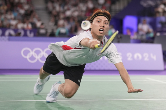 Japan's Kodai Naraoka plays Korea's Jeon Hyeok-jin in the men's singles badminton group stage match in Paris on Wednesday.  [AP/YONHAP]