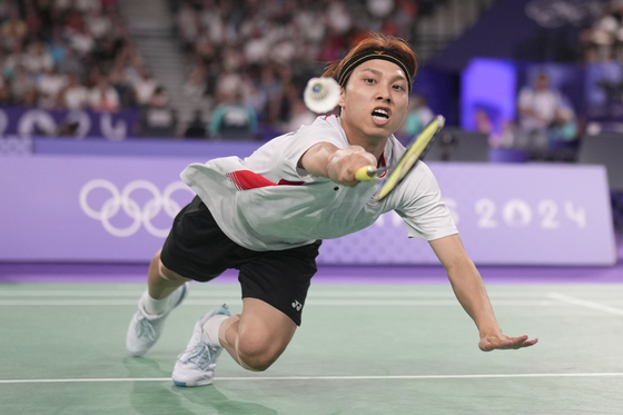 Japan's Kodai Naraoka plays Korea's Jeon Hyeok-jin in the men's singles badminton group stage match in Paris on Wednesday. [AP/YONHAP]