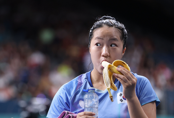 Table tennis player Shin Yu-bin eats a banana before the match with Hong Kong's Wong Chun Ting and Doo Hoi Kem at South Paris Arena 4 in France on July 30. [YONHAP]