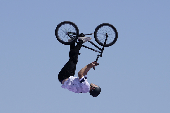 Justin Dowell of the United States performs a trick during the cycling BMX freestyle men's park final in Paris on Wednesday.  [AP/YONHAP]