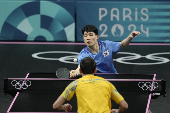 Korea's Jang Woo-jin, background, plays against Brazil's Hugo Calderano during a men's singles quarterfinal table tennis match at the 2024 Paris Olympics Thursday in Paris. [AP/YONHAP]
