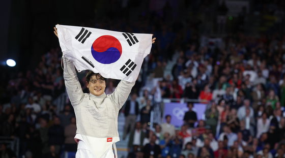 Fencer Oh Sang-uk spreads out the Korean flag after winning men's sabre individual at Grand Palais des Champs-Elysees in France on July 28. [YONHAP]