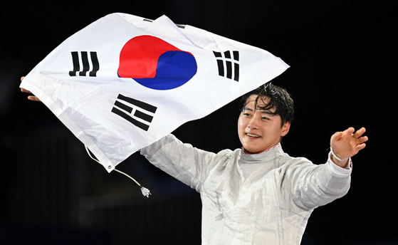 Fencer Oh Sang-uk spreads out the Korean flag after winning men's sabre individual at Grand Palais des Champs-Elysees in France on July 28. [YONHAP]