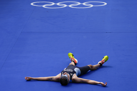 France's Leo Bergere lays on the floor at the end of the men's individual triathlon competition in Paris on Wednesday.  [AP/YONHAP]