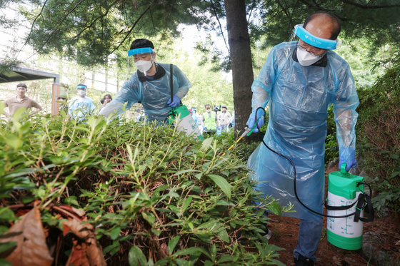 Officials responsible for malaria disinfection practice spraying pesticides at a neighborhood park in Gangseo District, western Seoul, following a quarantine education class on July 24. [NEWS1] 