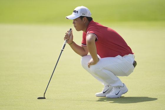 Korea's Tom Kim looks at the lie of his putt on the 5th green during the first round of the men's golf event at the Paris Olympics at Le Golf National in Saint-Quentin-en-Yvelines, France on Thursday.  [AP/YONHAP]