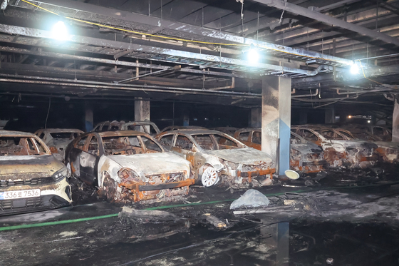 Cars left burnt in an underground parking lot in Incheon. A total of 140 cars were damaged in a fire caused by a Mercedes-Benz EV explosion on Thursday, and of them, 40 were completely burned. [YONHAP]