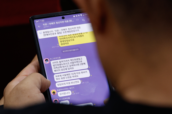 A seller checks messages in a group chat for sellers who have not received payments from Qoo10-owned e-commerce platforms TMON and WeMakePrice on Thursday. [NEWS1]