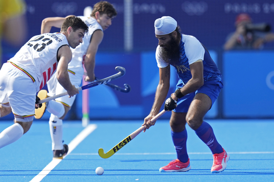 India's Jarmanpreet Singh, right, takes the ball away from Belgium's Arthur De Sloover reacts during the men's Group B field hockey match at the Yves-du-Manoir Stadium during the Paris Olympics on Thursday in Colombes, France. [AP/YONHAP]