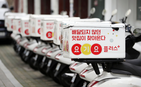 Yogiyo delivery motorcycles are lined up at a street in Seoul. [YONHAP]