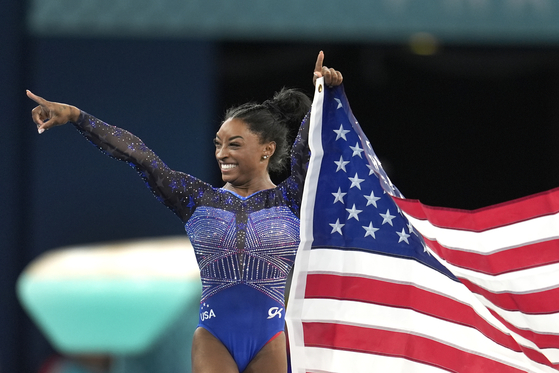 Simone Biles of the United States celebrates after winning the gold medal during the women's artistic gymnastics all-around finals in Paris on Thursday.  [AP/YONHAP]