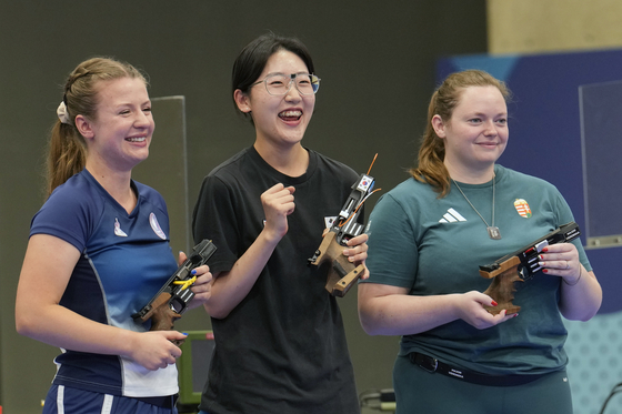 Korea's Yang Ji-in, center, France's Camille Jedrezejewski and Hungary's Veronika Major celebrate after the women's 25-meter pistol final at the 2024 Paris Olympics on Saturday in Chateauroux, France. [AP/YONHAP]