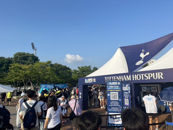 People await to take a photo with the mascot at a Tottenham Hotspur fan booth outside of the stadium before kickoff. [MARY YANG]