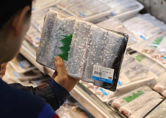 A shopper looks at cutlassfish fillets at a discount mart on April 21. The cutlassfish catch dropped by 70 percent in April this year due to higher water temperatures. [YONHAP]