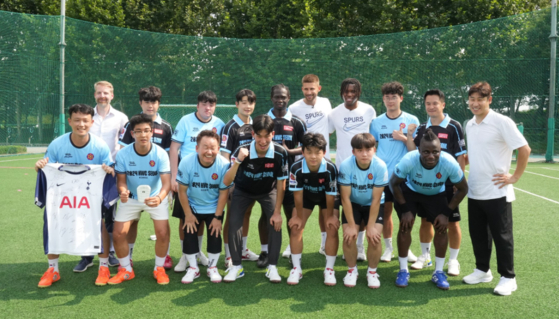 Korean Homeless World Cup players, in sky blue, and Tottenham Hotspur pose in Seoul on Friday. [FIFA]