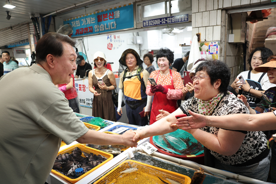 President Yoon Suk Yeol, left, chats with merchants at a traditional market in Geoje, South Gyeongsang, on Aug. 4, 2023, during his summer vacation. [PRESIDENTIAL OFFICE]