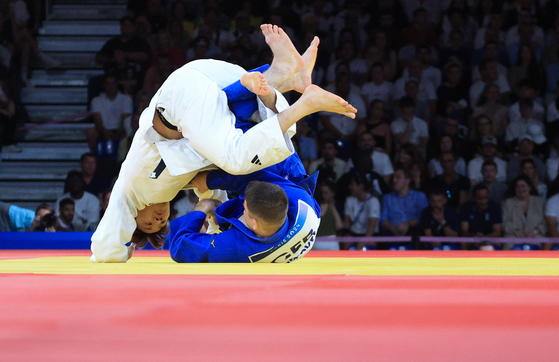 Korean judoka Lee Lee Joon-hwan, left, competes against Eduard Trippel of Germany in the mixed team bronze medal match at the Paris Olympics at the Champ-de-Mars Arena in Paris on Saturday. [NEWS1] 