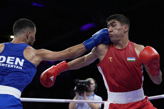Uzbekistan's Asadkhuja Muydinkhujaev, right, fights, Denmark's Nikolai Terteryan in their men's 71kilogram quarterfinal boxing match at the Paris Olympics on Saturday in Paris, France. [AP/YONHAP]