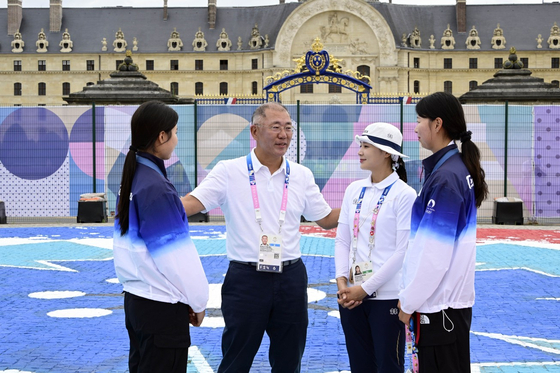 Hyundai Motor Group Executive Chair Euisun Chung, second from left, encourages members of the Korean women's archery team — Nam Su-hyeon, far left, Jeon Hun-young, second from right, and Lim Si-hyeon, far right — at the Paris Olympics on Saturday. [HYUNDAI MOTOR GROUP] 