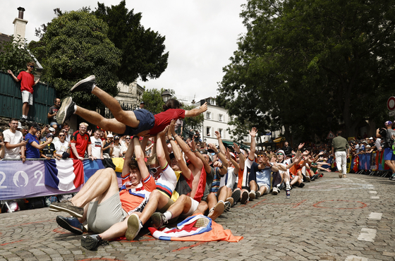 Spectators entertain themselves in Montmartre, Paris during the men's road cycling race on Saturday.  [REUTERS/YONHAP]