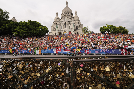 Luca Mozzato of Italy, center, rides past the Sacre Coeur basilica, during the men's road cycling event, at the Paris Olympics on Saturday in Paris, France. [AP/YONHAP]