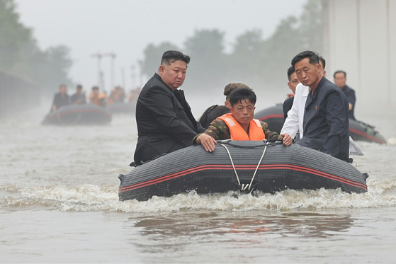 North Korean leader Kim Jong-un, left, inspects flooded areas in Sinuiju, a border city in North Pyongyan Province, following heavy rainfall earlier in the week in a photo carried by its official Korean Central News Agency on Wednesday. [YONHAP]